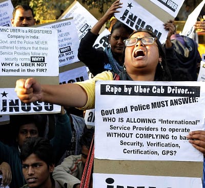 NEW DELHI, INDIA - DECEMBER 7: Jawaharlal Nehru University Students' Union (JNUSU) shout slogan against Delhi Police, hold protest against the shocking rape by UBER Cab Driver at PHQ ITO, on December 7, 2014 in New Delhi, India. A 27-year-old woman was allegedly raped by the driver of the cab she had hired through Uber to return home from a dinner party in Gurgaon on Friday night. The incident took place at around 9:30 pm when the woman, who works for a finance company in Gurgaon, was headed back to her home in north Delhi's Inderlok area. A rape case has been registered against the accused Shiv Kumar Yadav, 32 at Sarai Rohilla police station under Sections 376 (rape), 323 (voluntarily causing hurt) and 506 (criminal intimidation) of IPC. (Photo by Sonu Mehta/Hindustan Times via Getty Images)